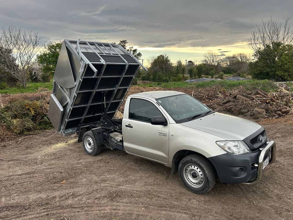 Tipper ute unloading wood chip and green waste